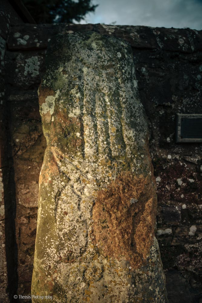 Side lighting reveals the symbols carved into the stone.